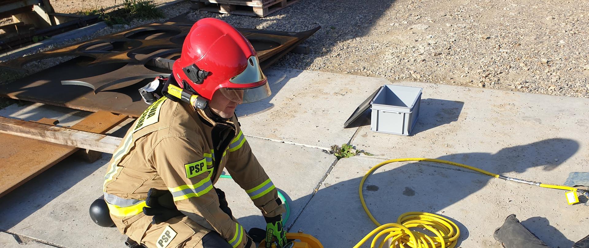 Strażacy podnoszą ciężki element stalowy przy użyciu sprzętu pneumatycznego