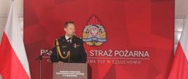 Komendant Powiatowy Państwowej Straży Pożarnej w Człuchowie stoi przy mównicy i wita zaproszonych gości zgromadzonych w pomieszczeniach jednostki ratowniczo – gaśniczej.