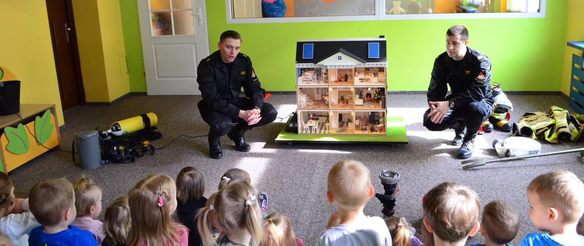 Strażacy opowiadają dzieciom w żłobku.