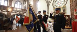 Zdjęcie przedstawia poczet sztandarowy ze sztandarem KP PSP w Wałczu oddający honory w trakcie mszy świętej z okazji Dnia Strażaka w kościele pw. Św. Antoniego w Wałczu 