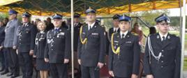 W rzędzie pod namiotem okolicznościowym stoi komendant powiatowy PSP w Żyrardowie st. bryg. Mariusz Tymoszewicz i asp. Tomasz Badowski oraz inni zaproszeni na uroczystość goście honorowi