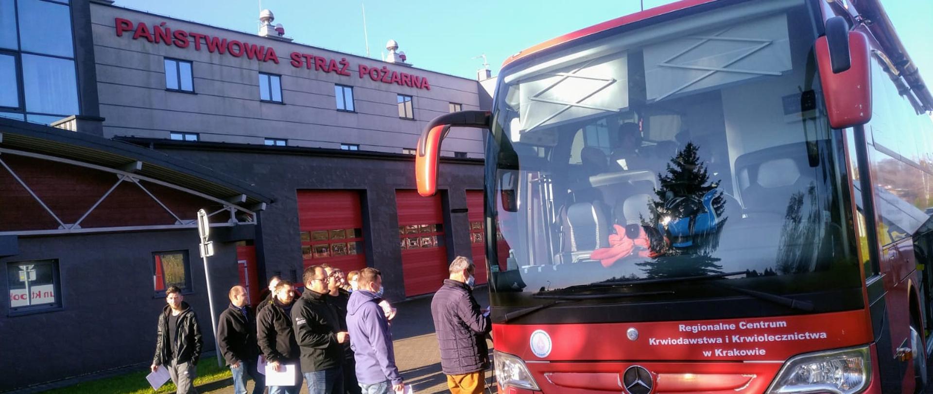 Kolejka ludzi do autobusu na placu KM PSP w którym można oddać krew.