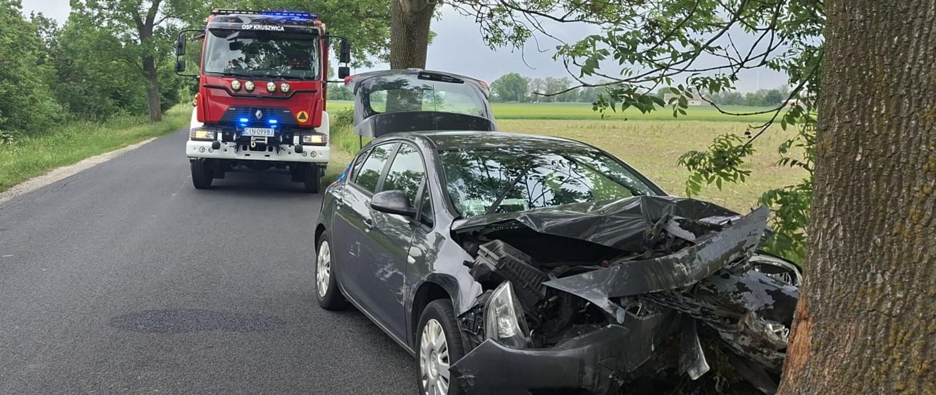 Uszkodzony samochód osobowy biorący udział w zdarzeniu, a w tle stoi pojazd GBA 4/30/4,7 - Renault z OSP Kruszwica