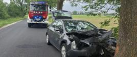 Uszkodzony samochód osobowy biorący udział w zdarzeniu, a w tle stoi pojazd GBA 4/30/4,7 - Renault z OSP Kruszwica