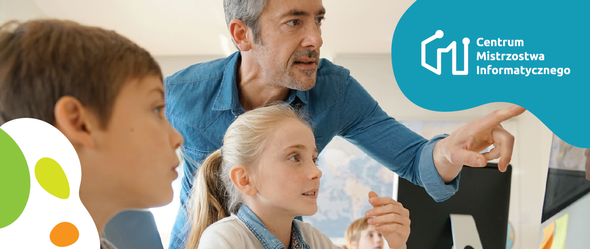 Na zdjęciu widzimy nauczyciela tłumączego dwójce dzieci co dzieję się na ekranie komputera.