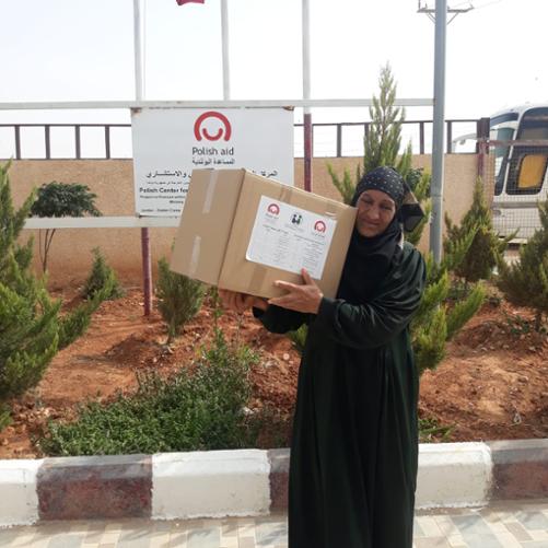 kobieta w tradycyjnym stroju niesie paczkę