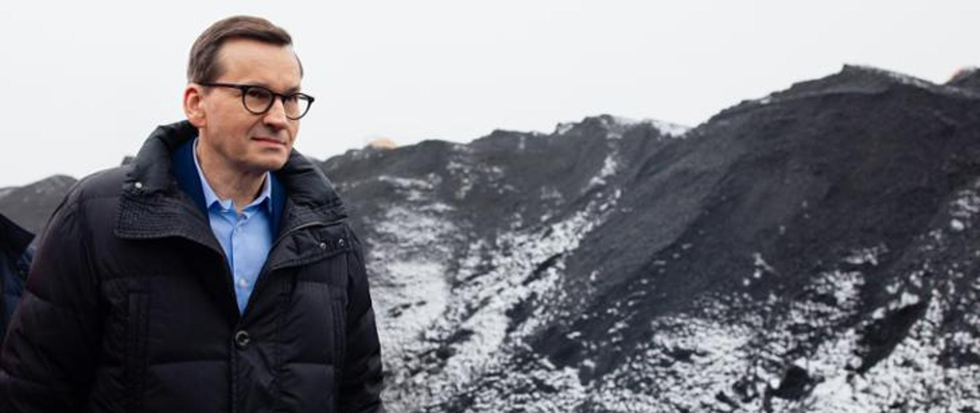 Na pierwszym planie - mężczyzna w okularach, ciemnej kurtce.