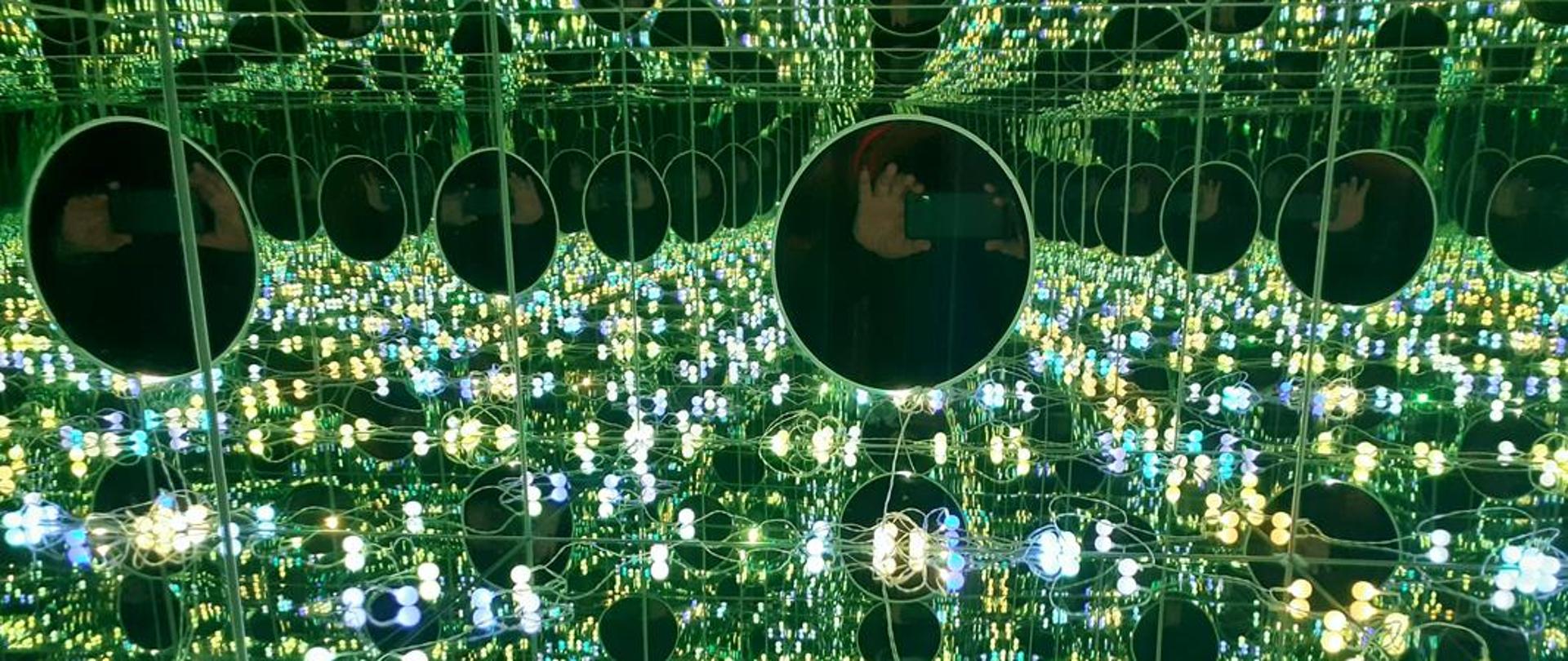 Na zdjęciu pomieszczenie pełne luster, a w nich odbijające się światło