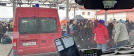 Czerwone busy do przewozu osób na granicy Polsko – Ukraińskiej, uchodźcy czekający na transport. 