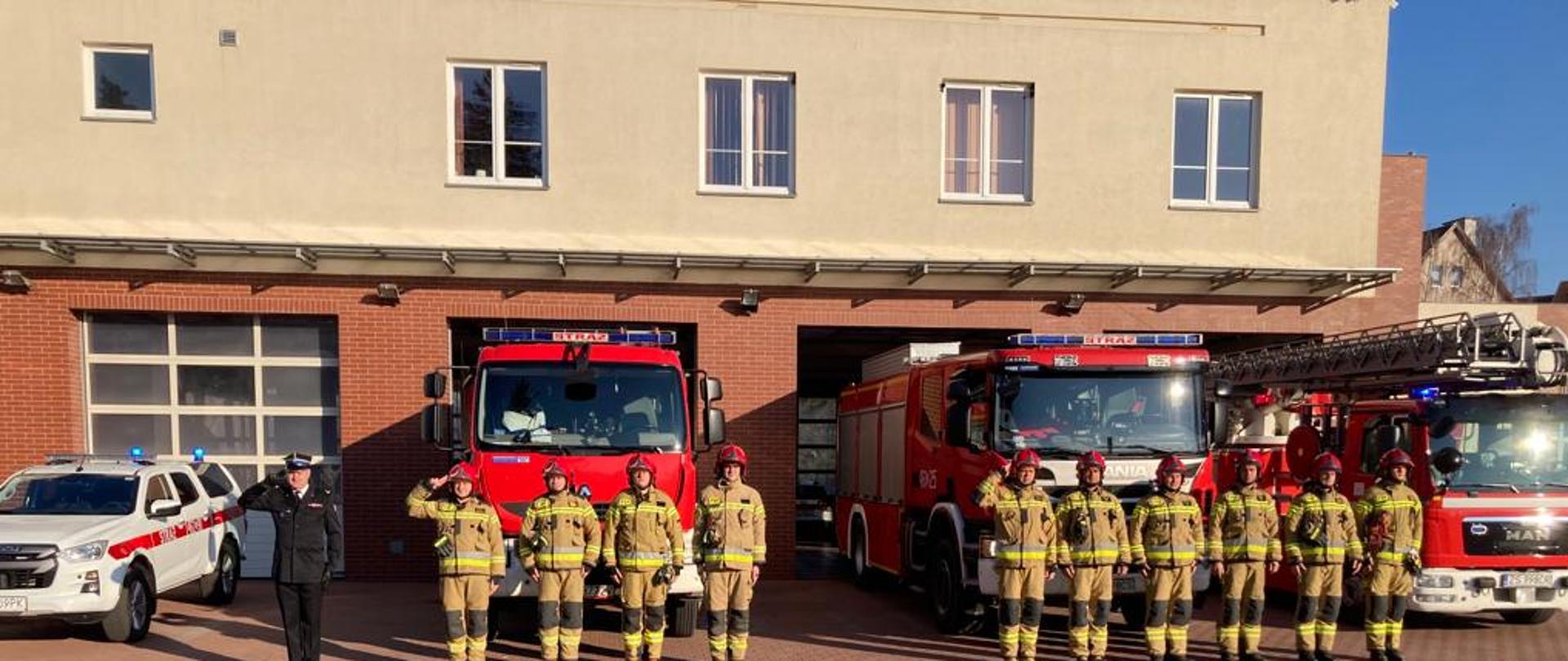 Pracownicy PSP na tle jednostki i samochodów.