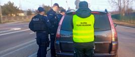 Funkcjonariusze KAS i policji przy aucie