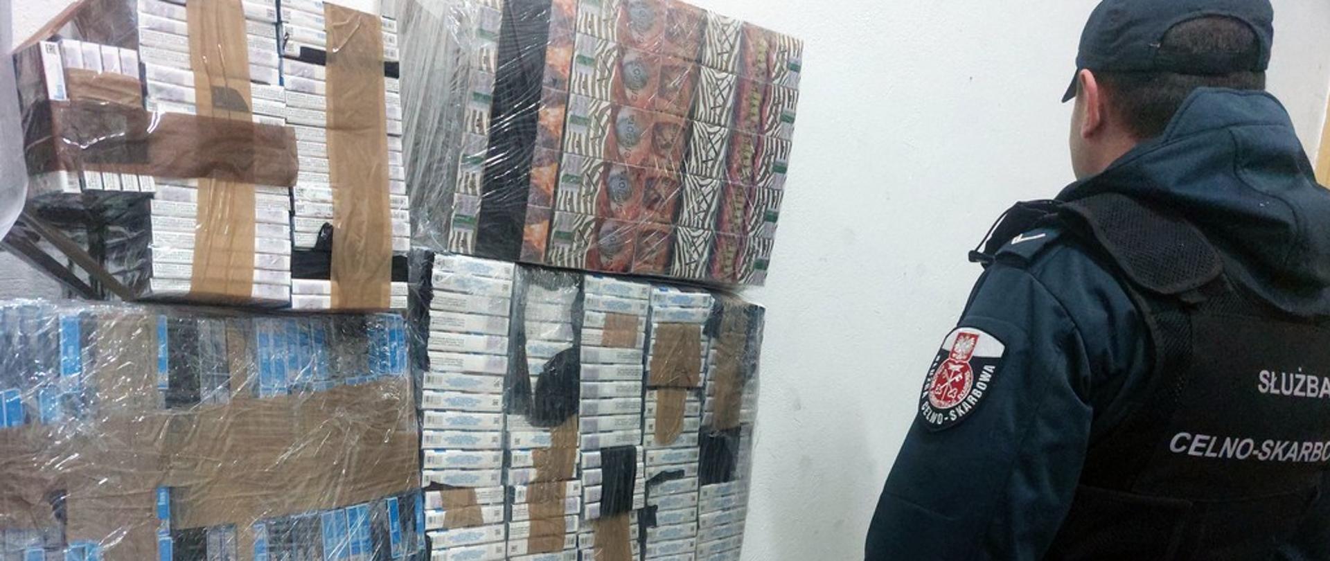 Funkcjonariusz przy zabezpieczonych papierosach