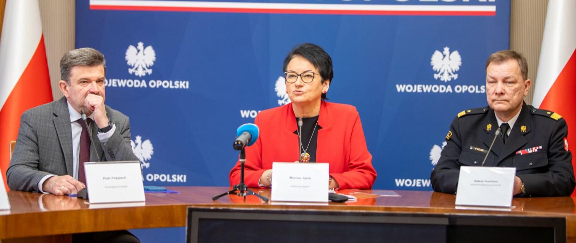 Konferencja prasowa inaugurująca cykl spotkań kampanii OLiOC. Przy stole siedzą wicewojewoda Piotr Pośpiech, Wojewoda Opolski Monika Jurek i oraz nadbryg. Paweł Kielar – Opolski Komendant Wojewódzki PSP.