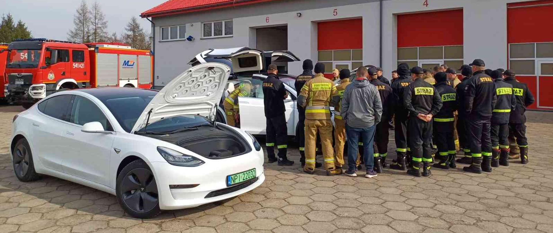 Strażacy słuchający informacji na temat pojazdów elektrycznych