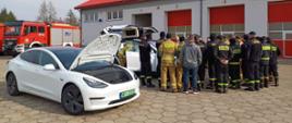 Strażacy słuchający informacji na temat pojazdów elektrycznych