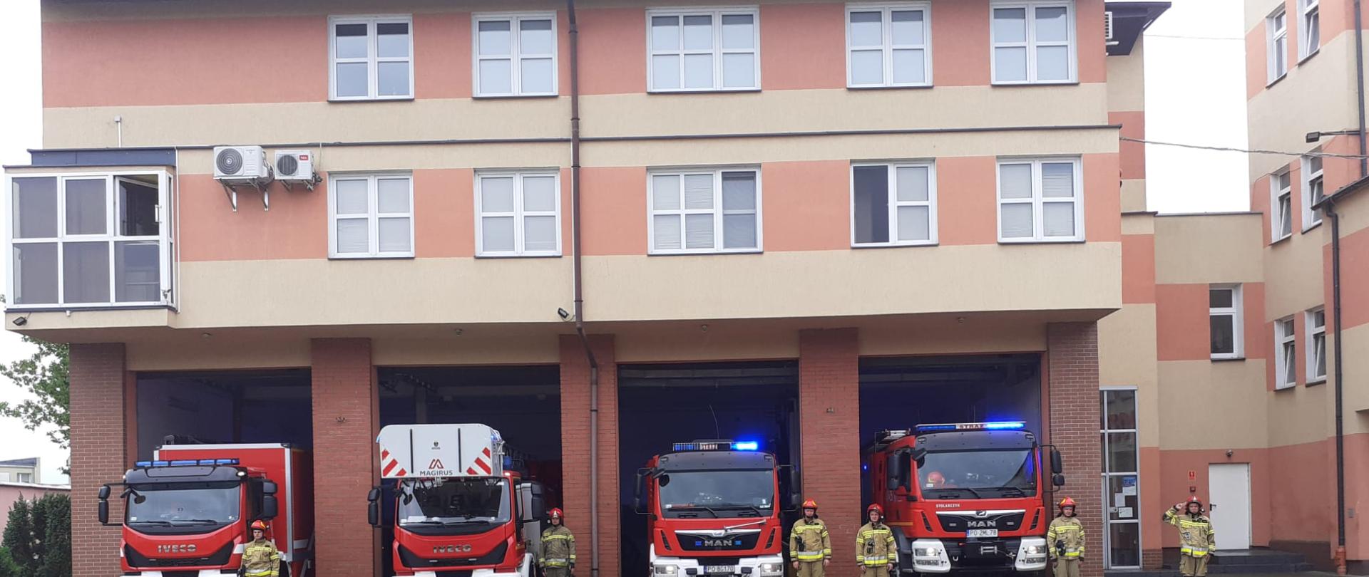 Zdjęcie przedstawia strażaków, którzy W 77. rocznicę wybuchu Powstania Warszawskiego strażacy z Chodzieży oddają hołd Powstańcom, stojąc na placu JRG przed samochodami strażackimi.
W tle budynek Jednostki. 