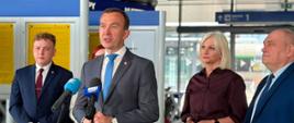 mężczyzna w szarym garniturze, wicewojewoda, przemawia przez mikrofon
