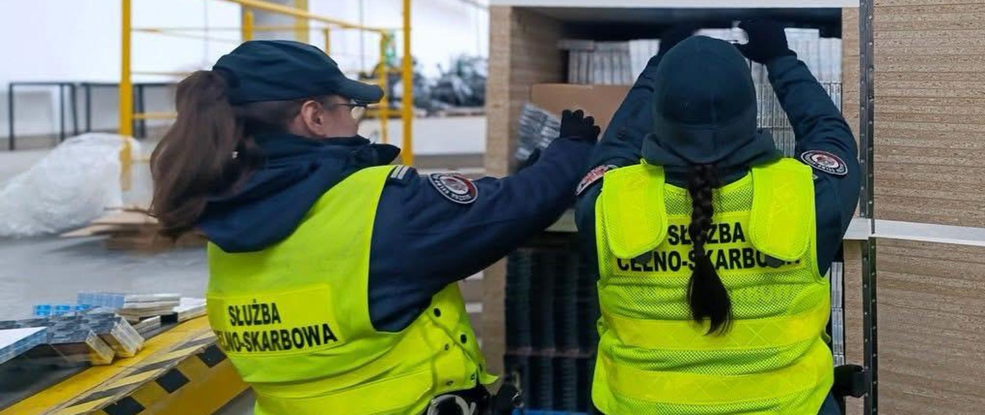 Dwie funkcjonariuszki w magazynie sprawdzają towar na regale. 