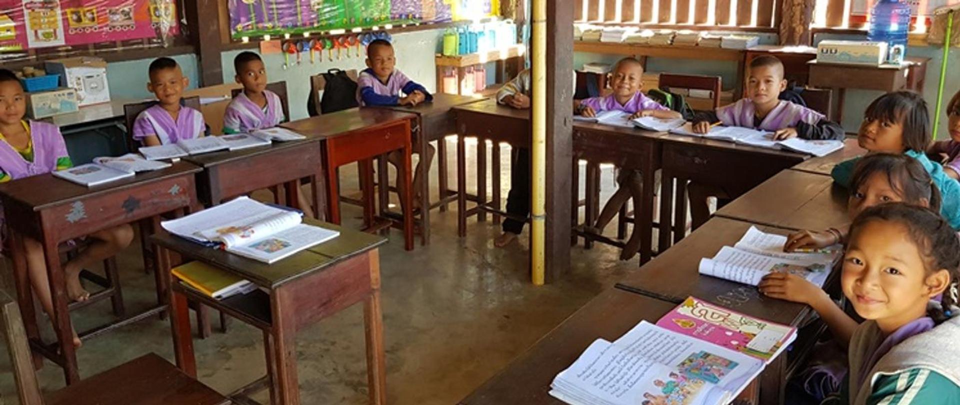 Children sitting at school desks with books