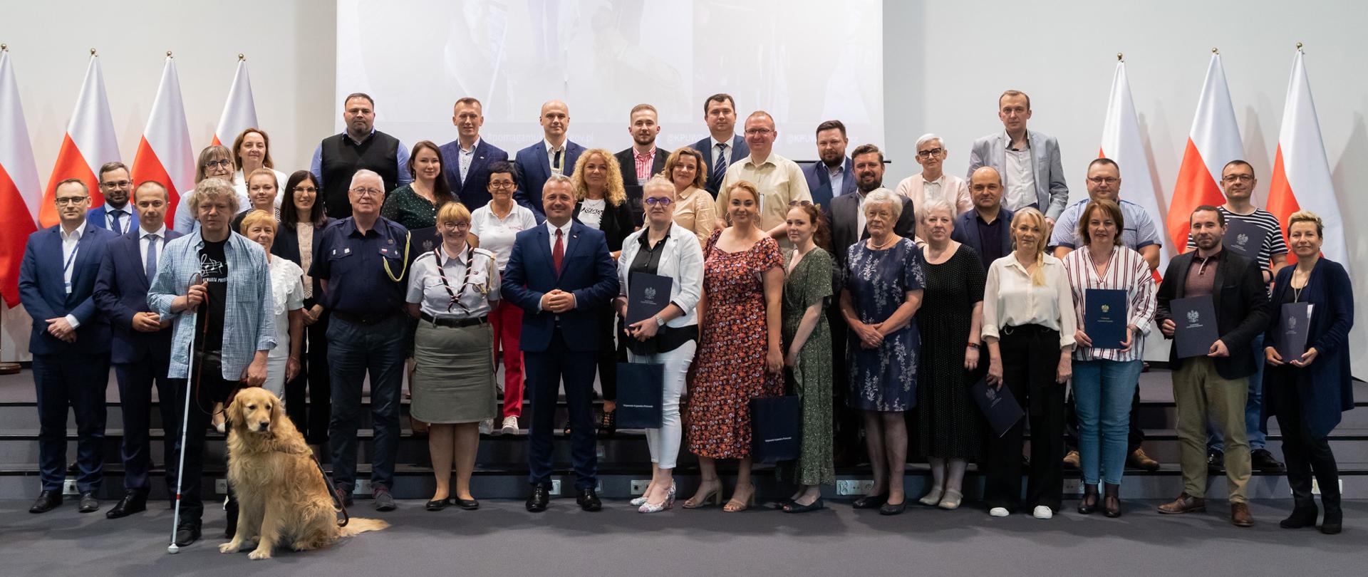 
Grupa osób siedząca przy stołach