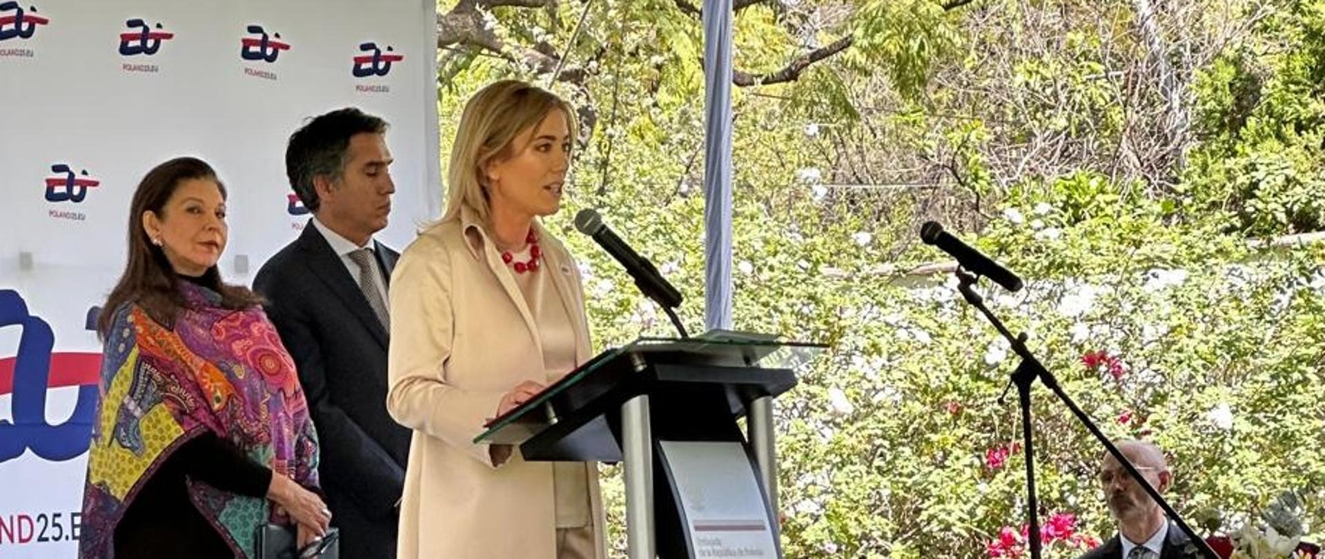 Na zdjęciu widać stojącą w plenerze przy mównicy Ambasador RP w Meksyku, Agnieszkę Frydrychowicz-Tekieli. W tle Ambasador UE w Meksyku oraz Podsekretarz Teresa Mercado.