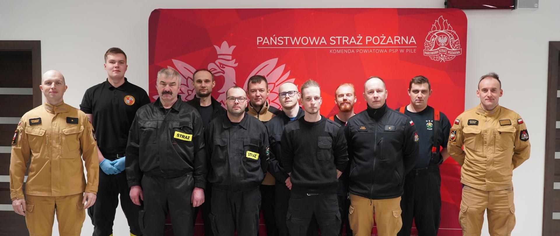 Na zdjęciu przedstawieni są strażacy w trakcie egzaminu z zakresu kwalifikowanej pierwszej pomocy. 