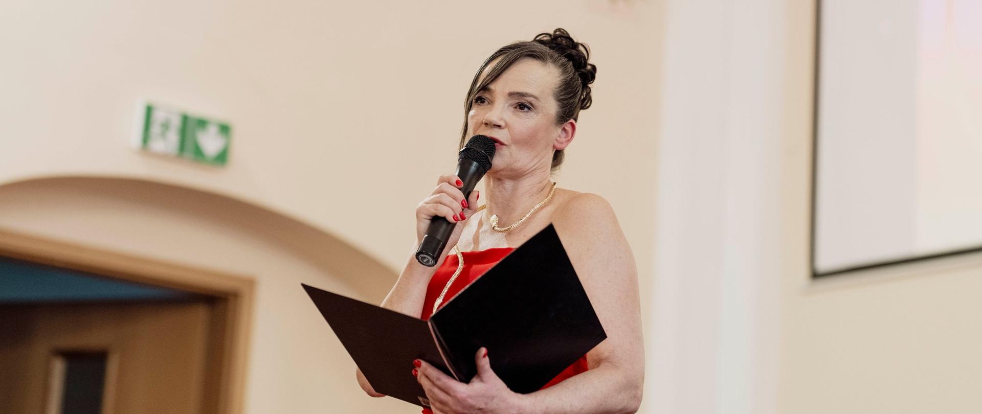 Pani Dyrektor Sonia Wachowska przemawiająca na scenie w sali koncertowej podczas Koncertu Świątecznie - symfonicznie. Lublinieccy artyści klasycznie w Państwowej Szkole Muzycznej I stopnia w Lublińcu
