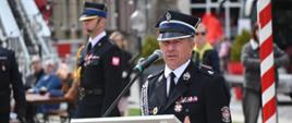 Prezes zarządu oddziału powiatowego związku ochotniczych straży pożarnych przemawia do obecnych podczas uroczystości z mównicy