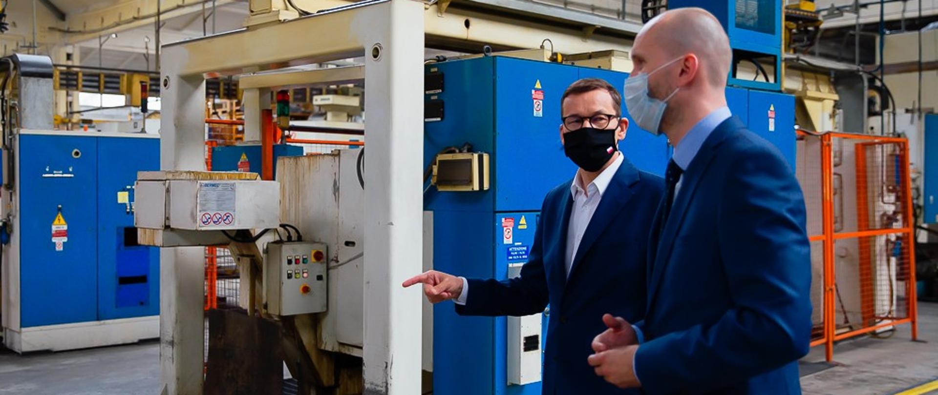 Premier oraz właściciel firmy idą po zakładzie.