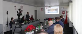 Uczestnicy konferencji prezentującej inwestycje w gminie Borowa, na ekranie zdjęcie zbiornika retencyjnego Sicina.