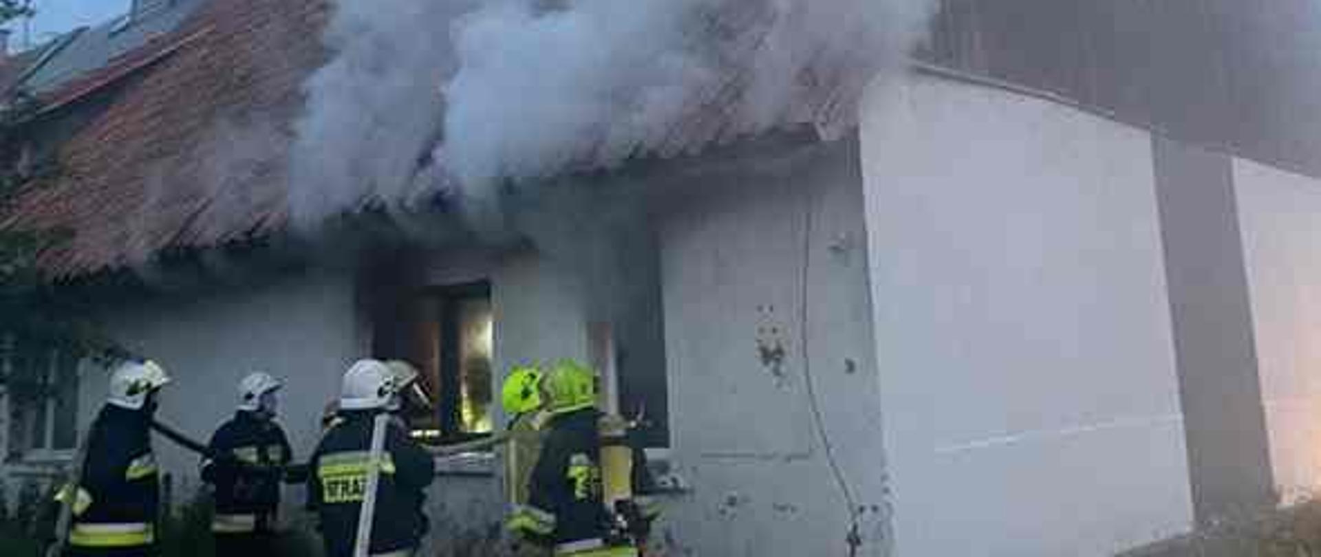 Palące się mieszkanie, dym wydobywa się z okien.