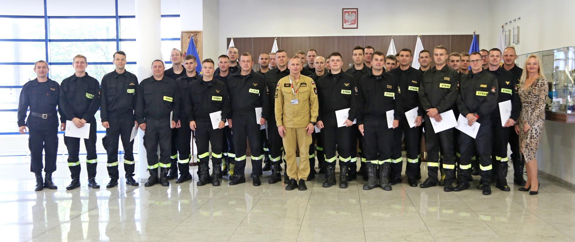 Grupowe zdjęcie uczestników szkolenia (31 osób) w towarzystwie Zastępcy Komendanta Centralnej Szkoły PSP oraz z dwójki pracowników Szkoły