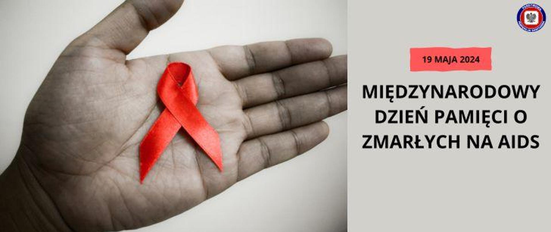 Po prawej na szarym tle ciemny napis Międzynarodowy Dzień Pamięci o Zmarłych na AIDS, powyższej na czerwonym polu ciemny napis 19 maja 2024, w prawym górnym rogu logo Państwowej Inspekcji Sanitarnej. Po lewej dłoń na której leży czerwona kokardka.