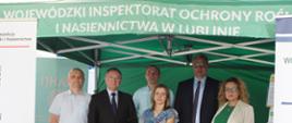Czterech mężczyzn i dwie kobiety stoją pod namiotem Wojewódzkiego Inspektoratu Ochrony Roślin i Nasiennictwa w Lublinie. Obok stoi rolap Inspekcji.