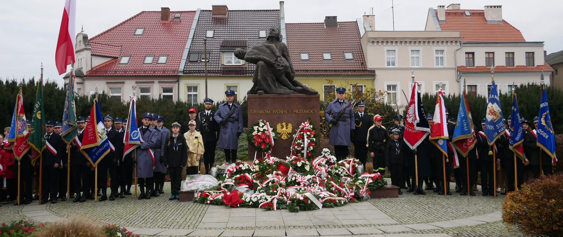 Na zdjęciu znajduje się pomnik przy którym ustawione są poczty sztandarowe, warta oraz zaproszeni goście