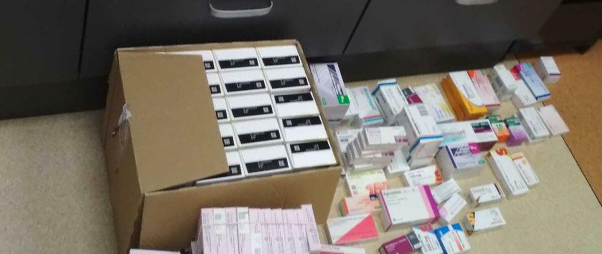 Opakowania z lekami na podłodze.