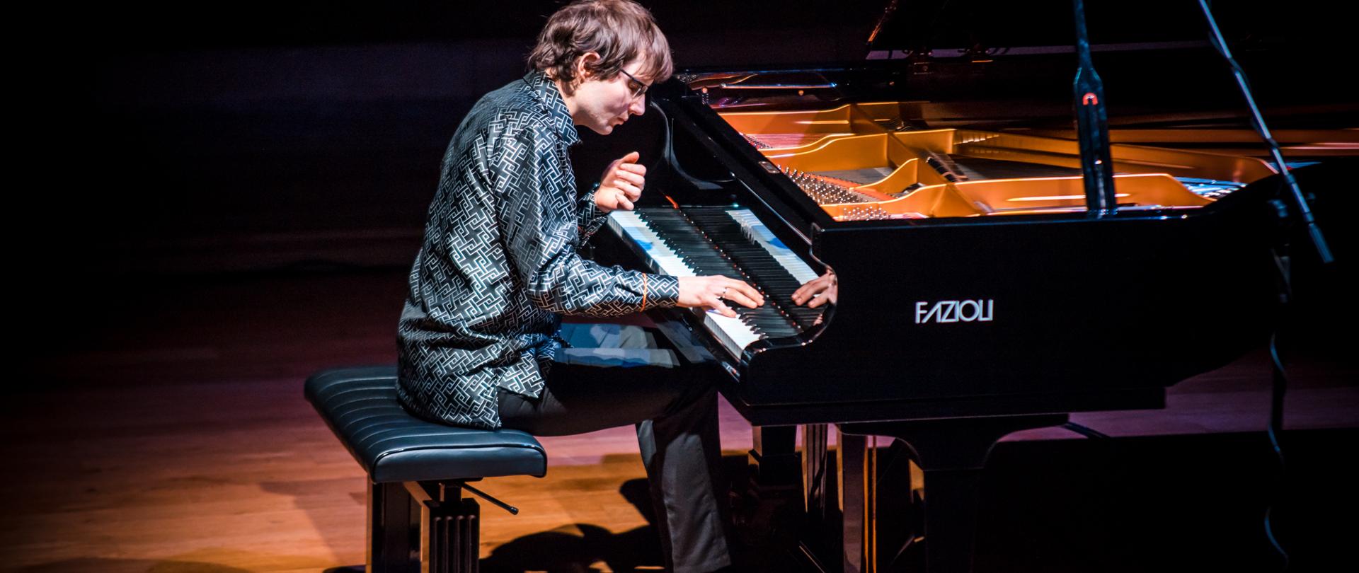 Zdjęcie przedstawia grającego artystę na fortepianie Fazzioli