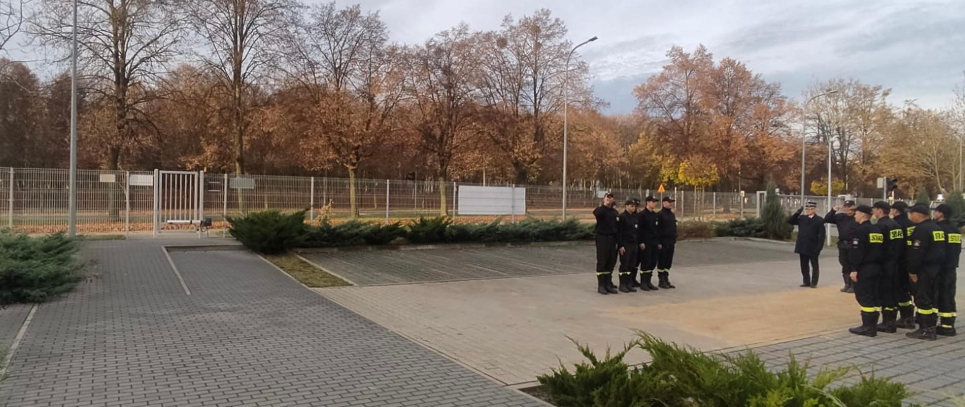 Na zdjęciu przed KP PSP w Śremie stoją strażacy podczas zmiany służbowej na przeciwko siebie zmiany służbowe 