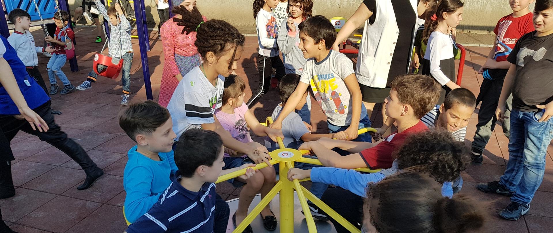 grupa dzieci bawiąca się na placu zabaw 