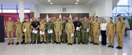 Pamiątkowe zdjęcie grupowe funkcjonariuszy PSP oraz Straży Granicznej będących uczestnikami szkolenia w zakresie przeciwdziałania zagrożeniom CBRNE (25 osób) w towarzystwie trzech funkcjonariuszy CS PSP oraz kobiety