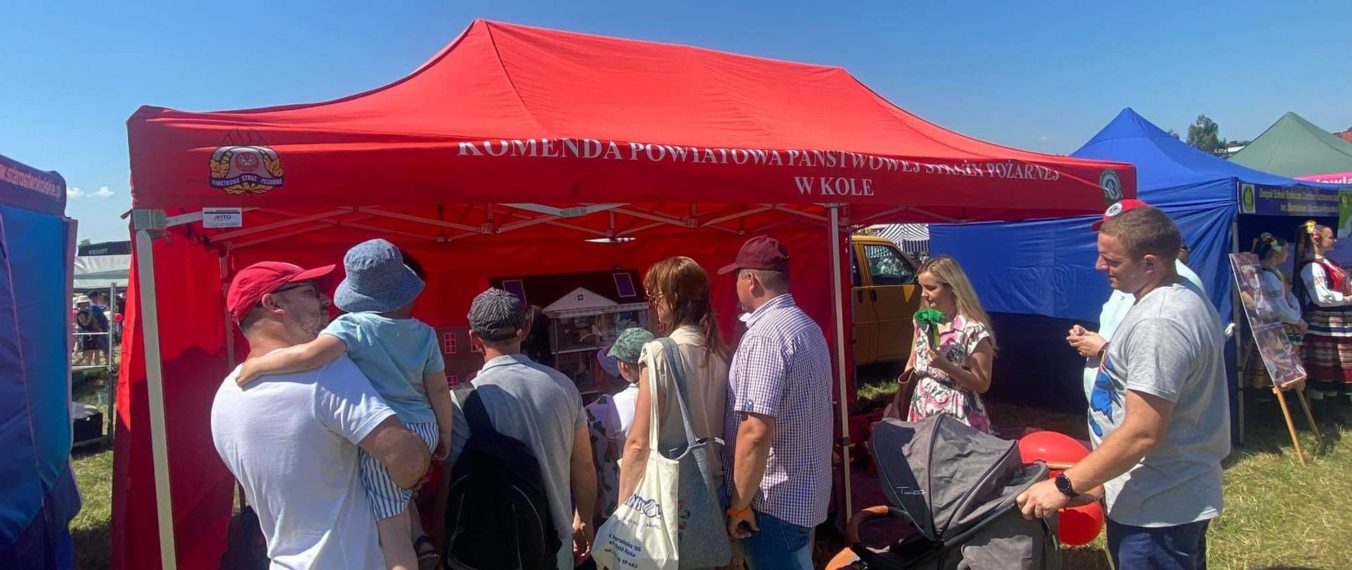 Na zdjęciu widać stoisko edukacyjne KP PSP KOŁO oraz zebranych wokół niego ludzi