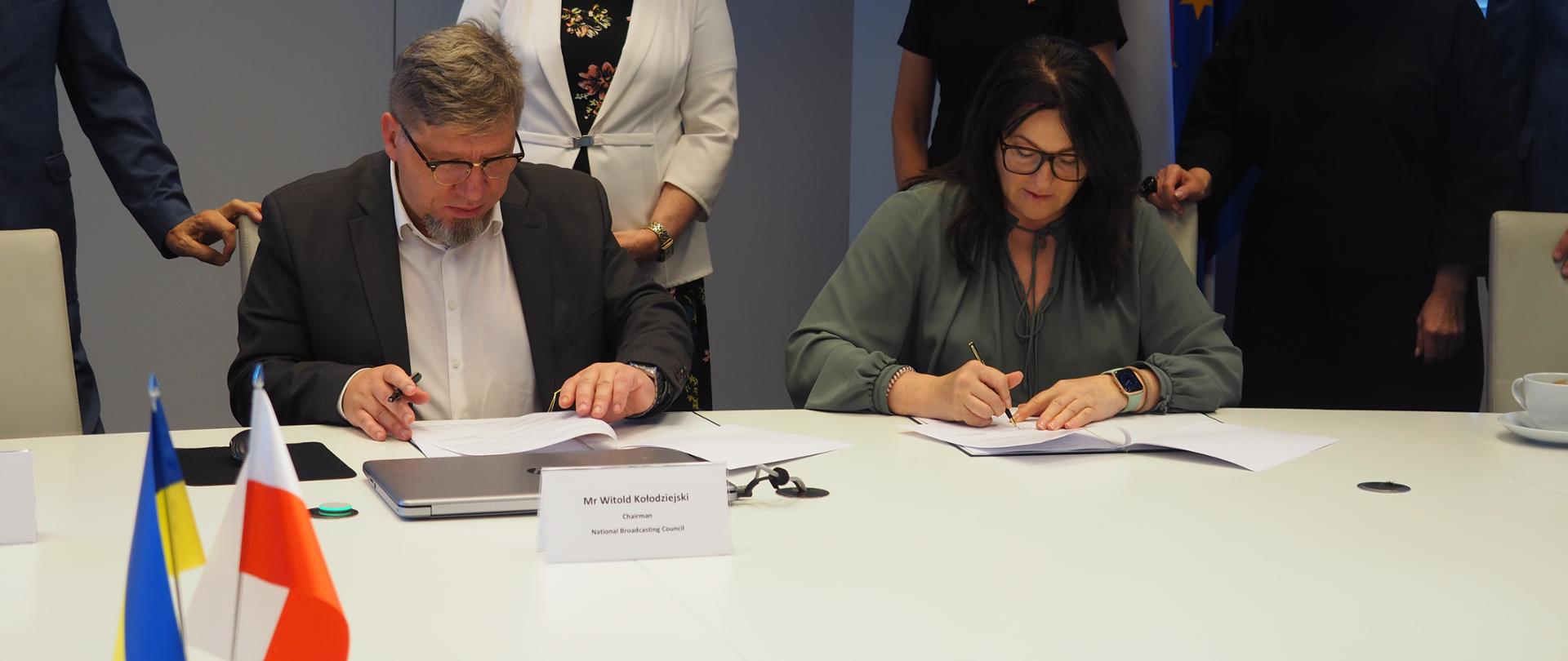 Zdjęcie w poziomie. Przewodniczący regulatorów podpisują dokument. 