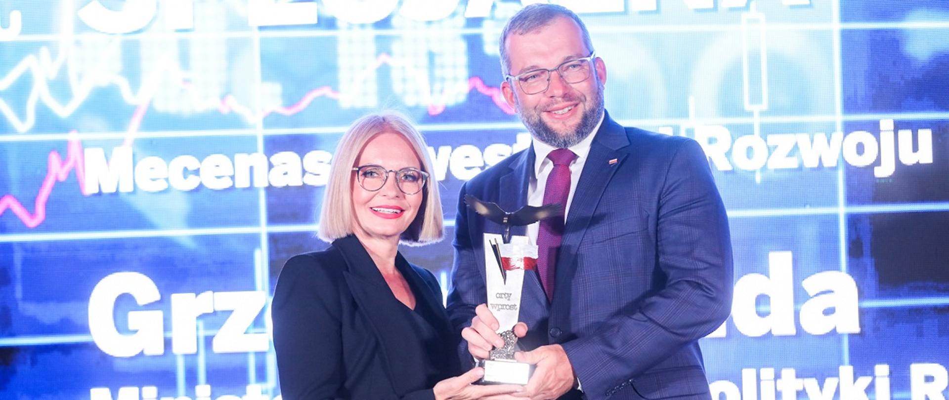 Minister funduszy i polityki regionalnej Grzegorz Puda trzyma w dłoniach statuetkę nagrody specjalnej Mecenasa Inwestycji i Rozwoju Polskiej Gospodarki podczas Gali 200 największych firm tygodnika Wprost
