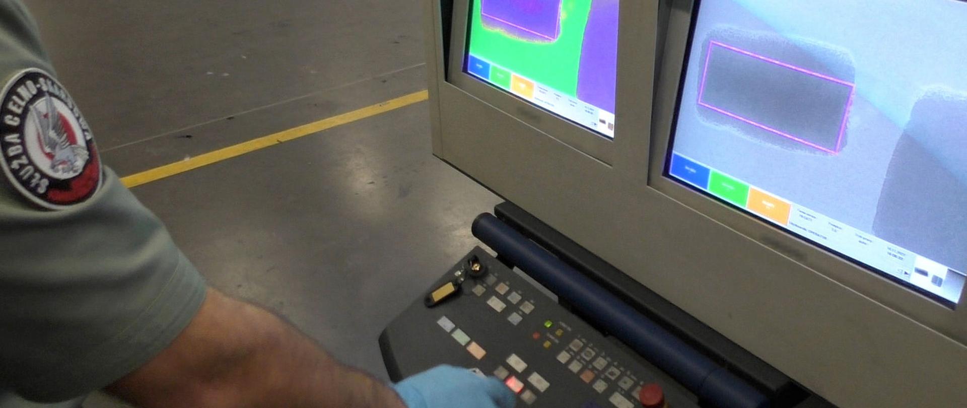 Ręka funkcjonariusza obsługującego skaner, monitory z prześwietlonym ładunkiem.