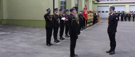 Dowódca uroczystości składa meldunek Łódzkiemu Komendantowi Wojewódzkiemu PSP. W tle pododdziały strażaków