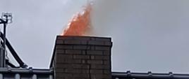 wydobywający się ogień z przewodu kominowego.