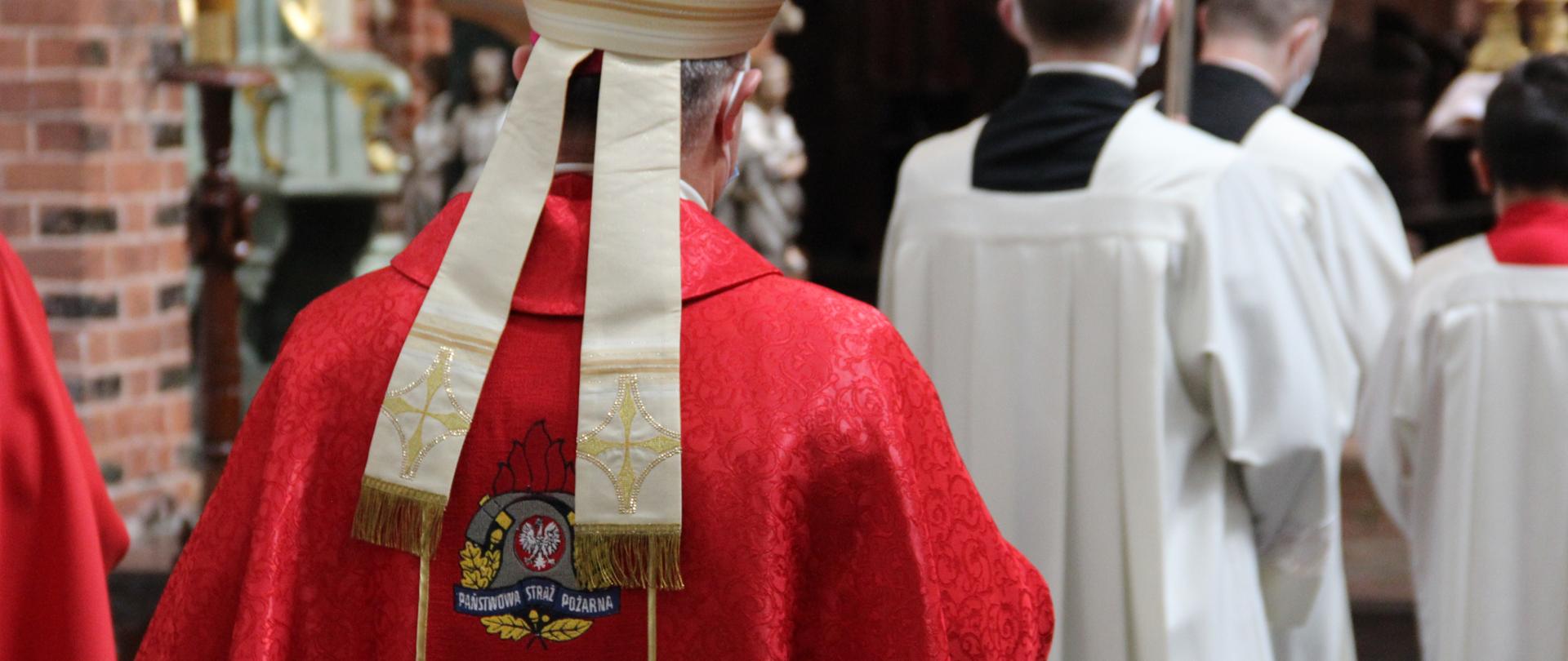 Na zdjęciu biskup, odziany w szatę z logo PSP na plecach - w trakcie procesji do ołtarza.