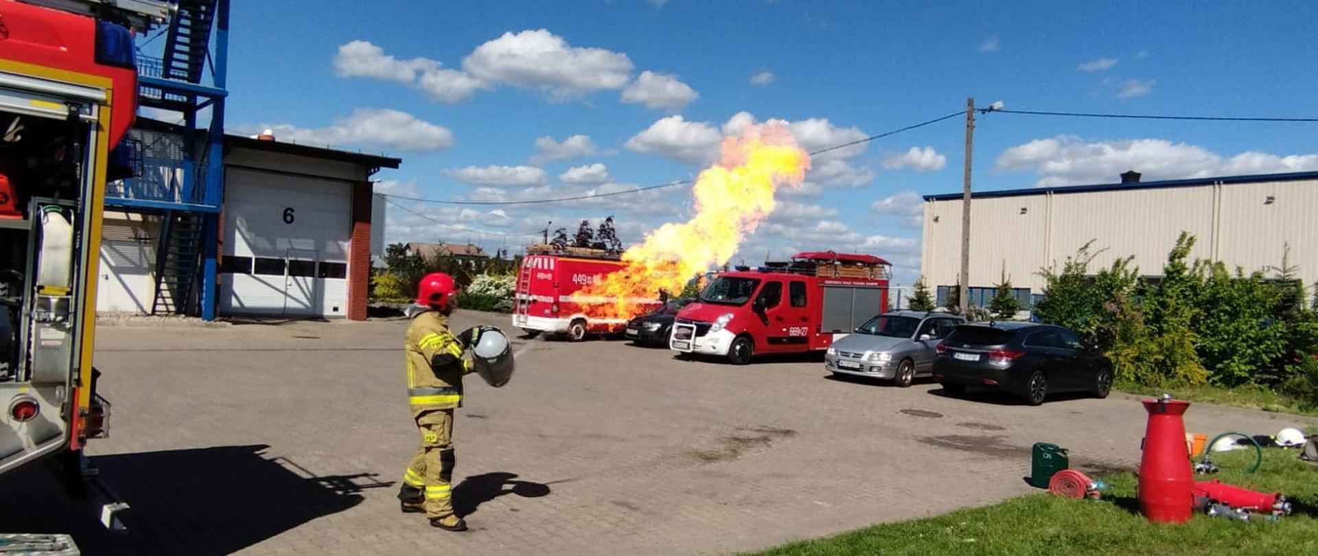 Strażak pokazuje jak pali się gaz z butli leżącej a jak ze stojącej