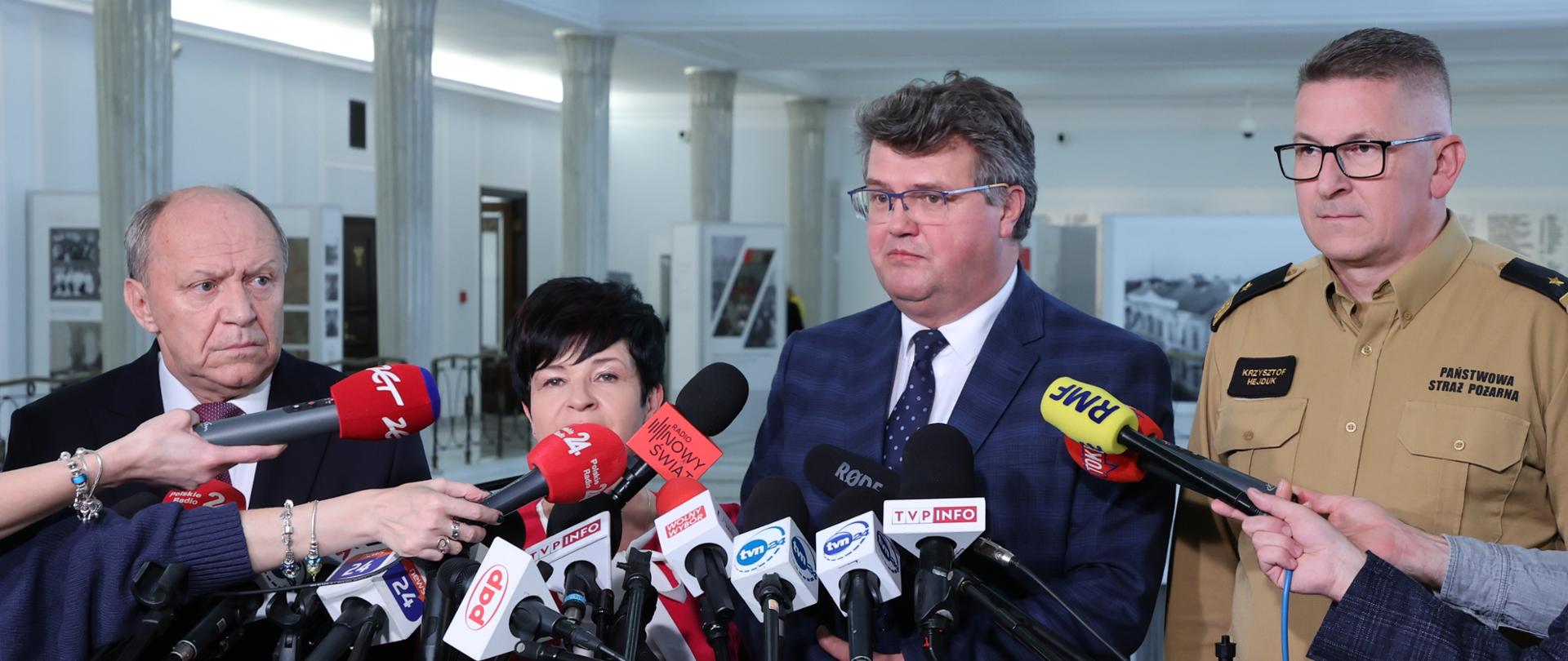 Na zdjęciu widać cztery osoby podczas briefingu prasowego w gmachu Sejmu RP