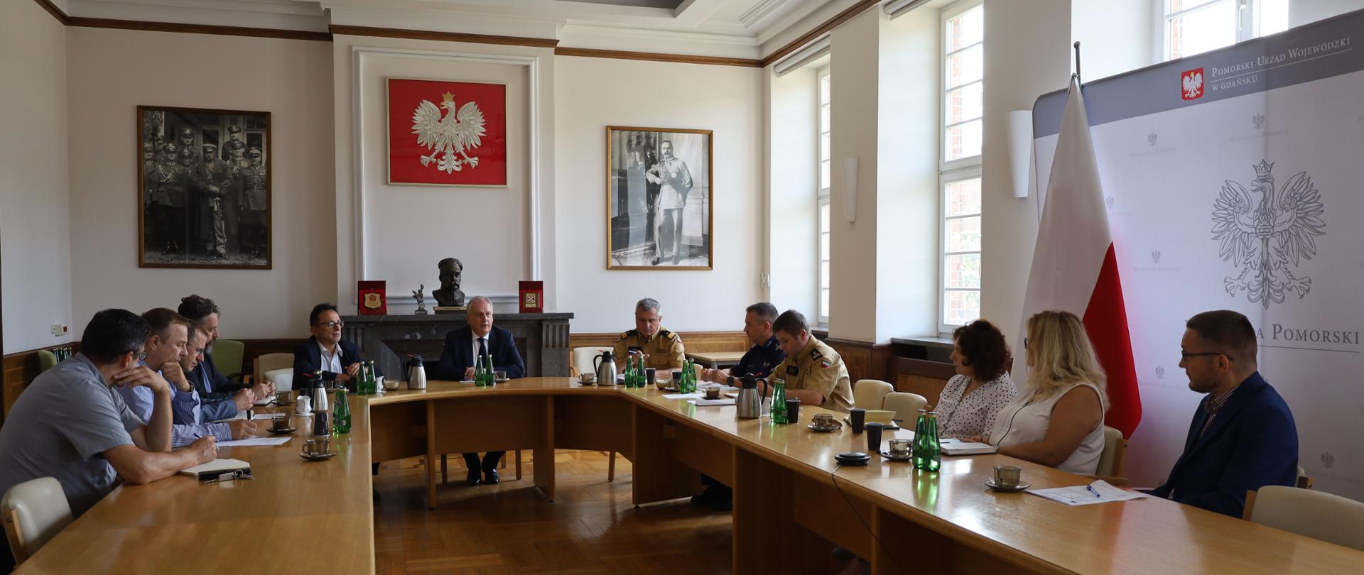 W sali przy podłużnym stole siedzą przedstawiciele służb mundurowych oraz władz szczebla wojewódzkiego.